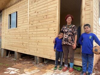 Na porta da casa nova, dona Izolda com dois dos 7 filhos que moram com ela. (Foto: Rosângela Borges/ON)