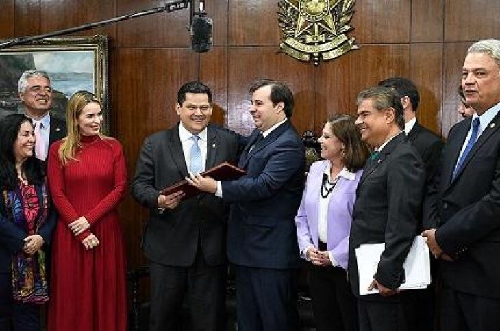 O presidente do Senado, Davi Alcolumbre, recebe de Rodrigo Maia o texto da proposta, observado pelos senadores Rose de Freitas, Major Olimpio, Daniella Ribeiro, Nelsinho Trad e Sérgio Petecão e por deputados